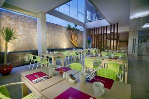 a restaurant with tables and chairs in a room at favehotel Langko Mataram - Lombok in Mataram