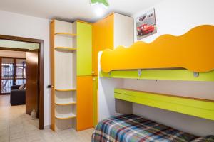Dormitorio infantil con litera y estanterías amarillas y blancas en Casa Erika, en Puntone di Scarlino