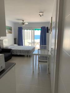 una camera con due letti e un tavolo e una sedia di Las Flores studio apartment a Playa Fañabe