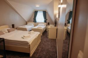 Piccola camera d'albergo con 2 letti e uno specchio di Hotel Kunst a Krško