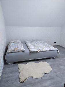 a bed with a rug on the floor in a room at Dom Przy Lesie in Istebna
