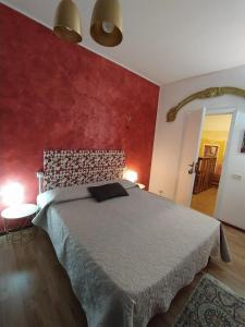 a bedroom with a bed and a red wall at Sabrina Suite in Milazzo