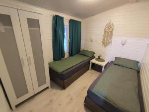 Habitación pequeña con 2 camas y mesa. en Къщички Морски Светулки en Sinemorets