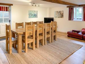 uma sala de jantar com uma mesa de madeira e cadeiras em Bakers Retreat em Cottesmore