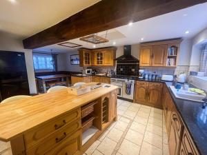 une grande cuisine avec des placards en bois et un comptoir. dans l'établissement Bakers Retreat, à Cottesmore