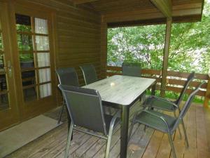 een houten tafel en stoelen op een veranda bij Twistesee Ferienhaus 110 in Bad Arolsen