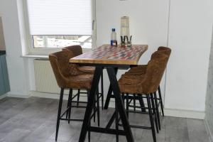 a dining room table with four chairs and a table with a checkerboard table at Ferienhaus Laila in Hochstetten-Dhaun
