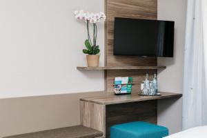 a room with a tv on a shelf with a blue stool at Tagungszentrum Blaubeuren in Blaubeuren