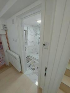 uma casa de banho branca com um chuveiro e um espelho. em Apartments Natural and Bungalows em Saraievo