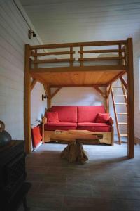 ein Hochbett mit einer roten Couch in einem Zimmer in der Unterkunft Le chalet du bout du monde, en bord de rivière ! in Grez-sur-Loing