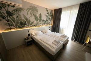 ein Schlafzimmer mit einem Bett mit einer tropischen Tapete in der Unterkunft Park Hotel Eden in Nago-Torbole