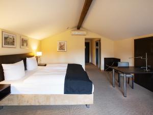 呂訥堡的住宿－多美洛老百貨酒店，配有一张床和一张书桌的酒店客房