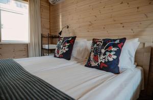 a bedroom with a bed with two pillows on it at Ošupio Vasarnamis in Šventoji