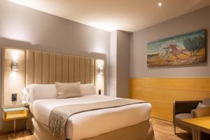 une chambre d'hôtel avec un lit et une chaise dans l'établissement Hotel Sansi Barcelona, à Barcelone
