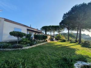 a house with a yard with trees and grass at La maison de vacances de Campoussin in Montfrin