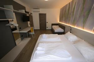 2 Betten in einem kleinen Zimmer mit 2 Betten in der Unterkunft Park Hotel Eden in Nago-Torbole