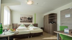 1 dormitorio con cama, mesa y escritorio en Zeitlers Hotel en Marsberg