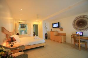 Wild Orchid Beach Resort في اولونجابو: غرفة نوم كبيرة مع سرير ومكتب ومكتب
