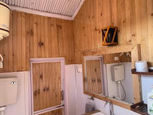 a bathroom with wooden walls and a sink and a mirror at THE WONDERLAND COTTAGES & Cafe in Nārkanda +71 photos