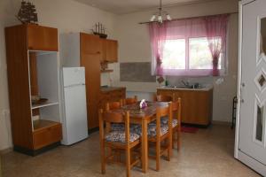 uma cozinha com uma mesa e cadeiras e um frigorífico em KIKI Stegna em Archangelos