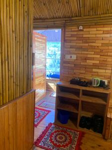 an entrance to a room with a wooden room with a door at THE WONDERLAND COTTAGES & Cafe in Nārkanda
