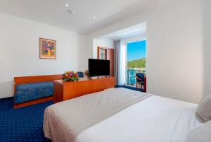 a hotel room with a bed and a television at Hotel Vis in Dubrovnik