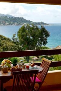 - une table sur un balcon avec vue sur l'océan dans l'établissement F2, climatisé, vue mer, 100 m de la plage, à Casaglione