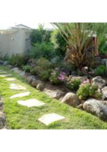 a garden with stepping stones in the grass at Helios Luxury Caravan's in Had Nes