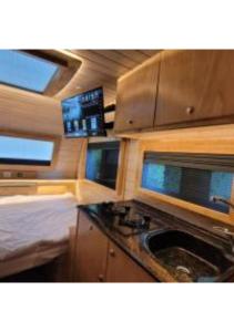 uma cozinha num trailer com um fogão e janelas em Helios Luxury Caravan's em Had Nes