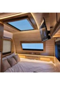 a bedroom with a bed and a flat screen tv at Helios Luxury Caravan's in Had Nes