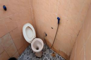 ein Bad mit einem WC in einer gefliesten Wand in der Unterkunft SPOT ON 92196 Kost Axcel in Banjarmasin