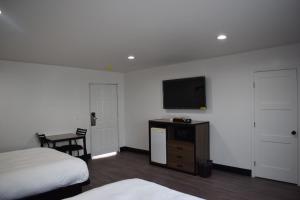 a hotel room with two beds and a flat screen tv at Hyde Park Motel in Los Angeles