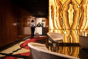 a woman standing in a lobby with a man at a counter at L-Avenue in Brussels