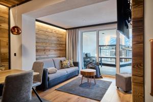una sala de estar con un sofá y una mesa en Relax Apartments Ladis, en Ladis