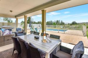 a patio with a table and chairs and a pool at Silver Springs Estate in Rothbury