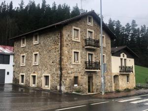 a stone building on the side of a street at Junto al Parque Natural de Urkiola in Ortúzar
