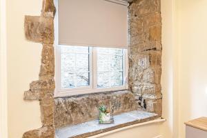 a window in a room with a stone wall at Scalebar Bridge End Mill in Settle
