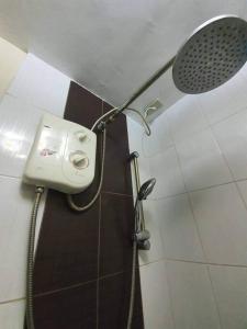 y baño con ducha y cabezal de ducha. en Cozy Place 2BR Condo Unit in Ortigas Ave Ext, en Cainta