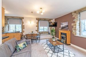 a living room with a couch and a fireplace at Scalebar Bridge End Mill in Settle