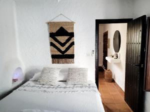 - un lit blanc avec deux oreillers dans une chambre dans l'établissement Casa Nomad es su hogar mágico en Agua Amarga, à Agua Amarga