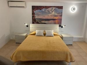 a bedroom with a large bed with a painting on the wall at Villa Bernardette in Xagħra