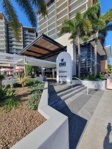 a hotel with a sign in front of a building at Mon Komo Seaview Privately Owned Apartment in Redcliffe