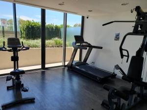 a gym with three exercise bikes and a large window at Mon Komo Seaview Privately Owned Apartment in Redcliffe