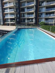 a large swimming pool in front of a building at Mon Komo Seaview Privately Owned Apartment in Redcliffe