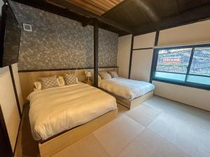 a bedroom with two beds and a window at Kototoki - Yu - in Gotsu