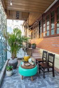 un patio con tavolo, 2 sedie e tavolo di Hanoi Retro 80S Homestay a Hanoi