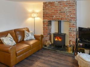 a living room with a couch and a fireplace at Beachview Cottage Scratby in Scratby