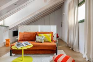a bedroom with an orange bed and a table at Calatrava - Darya Living in Madrid