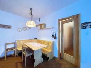 a dining room with a table and a blue wall at Dolomites Dream Marmolada in Rocca Pietore