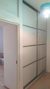 Apartament Szczęśliwicka في وارسو: خزانة مع أبواب منزلقة في غرفة